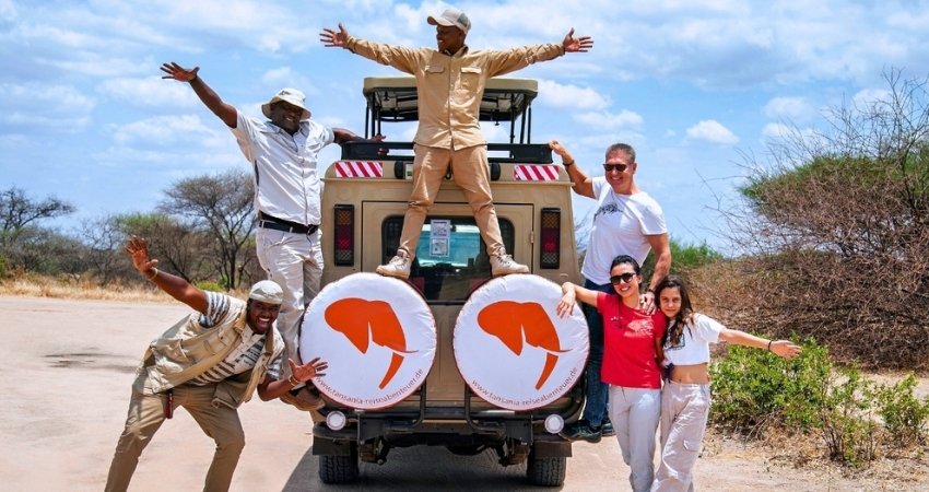 Touristen erkunden die Stadt mit einem lokalen Reiseleiter nach der Ankunft in Tansania Safari.
